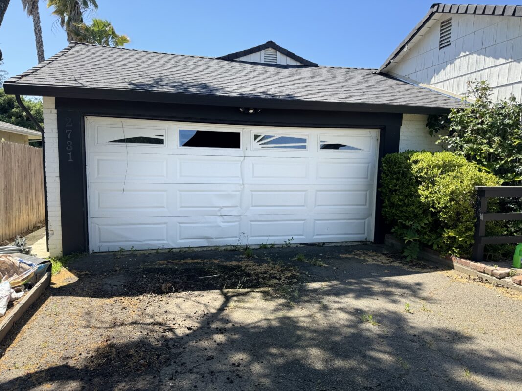 Dented garage door panel on a residential garage door in Sacramento